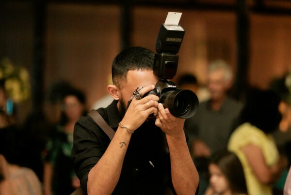 man in black t shirt holding black dslr camera